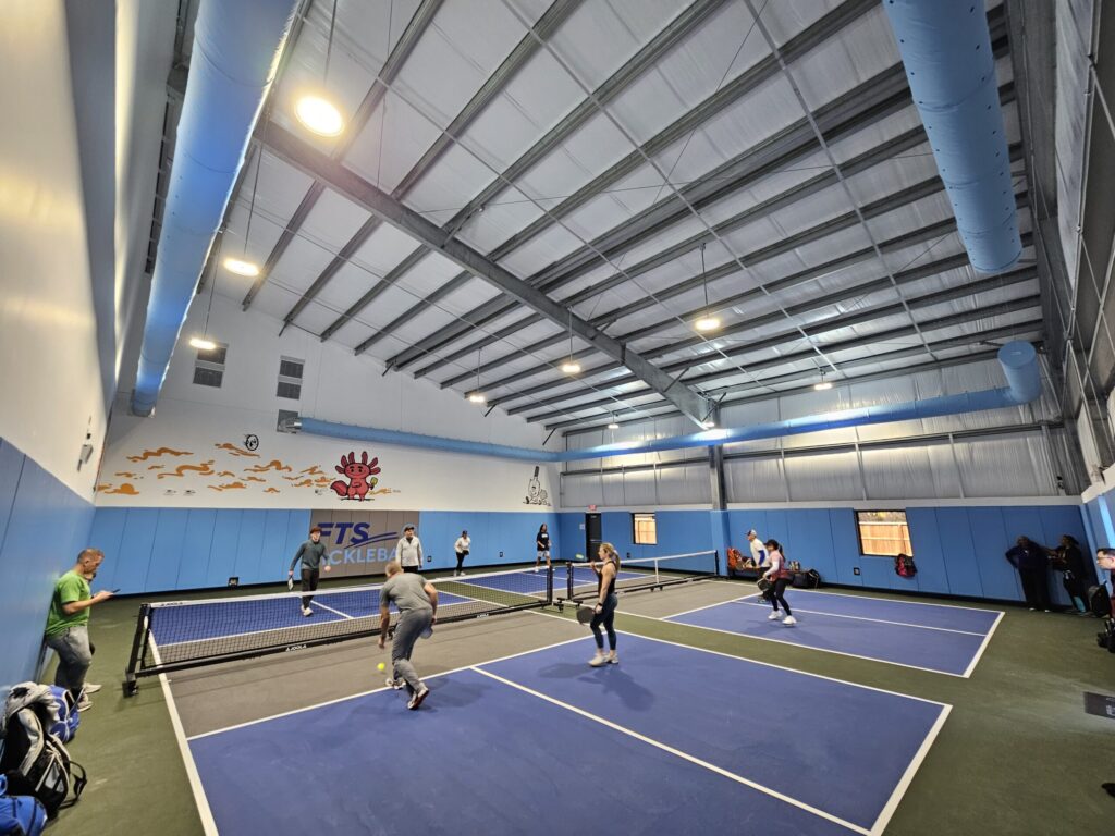 Picture of multiple people playing pickleball on FTS's 2 courts.